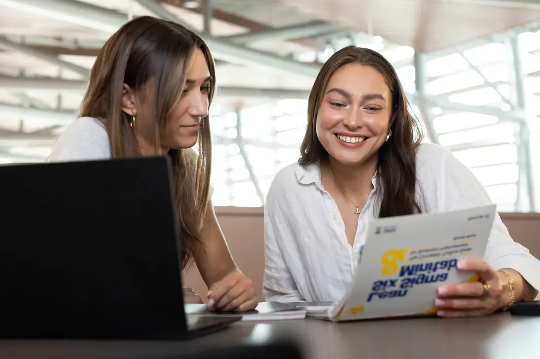 Two students looking at work together.